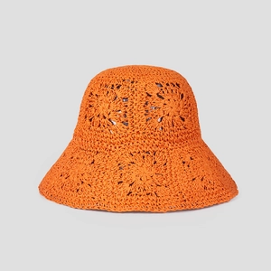 Macro detail of vibrant orange crochet sun hat showing intricate floral hollow knit patterns