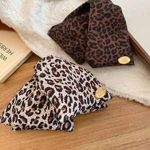 Detail of vintage leopard print triangular hair clips with premium golden metal labels