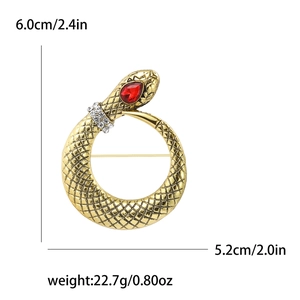 Golden vintage snake brooch with red gem eye and rhinestones on a white background