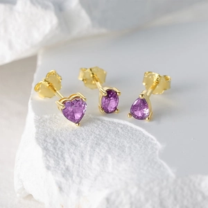 Macro shot of S925 silver earrings set with purple heart and pear shaped gemstones