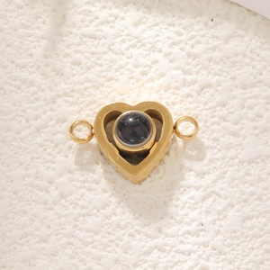 Close-up of heart-shaped gold stainless steel connector with a central projection stone