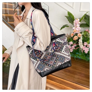 Close-up of ethnic tote bag showing geometric patterns and durable black leather bottom