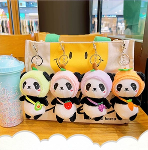 Detail of four panda plush keychains wearing avocado strawberry and fruit hats on a bag