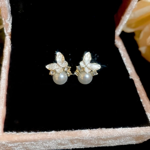 Macro detail of silver butterfly earrings with sparkling cubic zirconia and white pearls