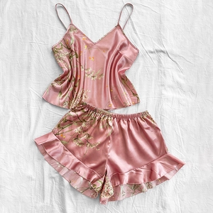 Two-piece floral satin pajama set with camisole and ruffled shorts in lotus pink color
