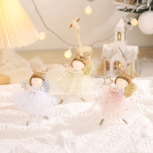 Three plush Christmas angel ornaments with antlers and wings on a warm knit background