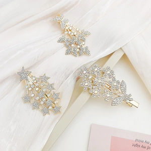 Close-up of gold metal hair clips with rhinestone butterfly, star, and flower motifs