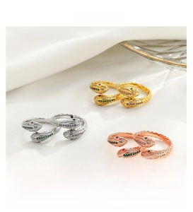 Macro shot of three double-headed snake rings with colorful zircon pavé on white silk