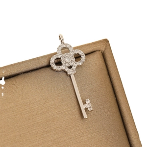 Sparkling silver key pendant with micro-pave cubic zirconia crystals on a gold texture