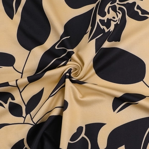 Close-up of black floral print on beige fabric showing textile texture and pattern