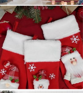Detail of plush Christmas stockings with 3D Santa and snowman on fireplace decor