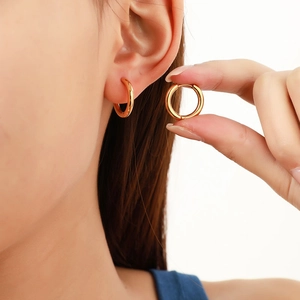 Minimalist 2.5mm golden titanium steel hoop earrings with polished finish on model