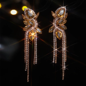 Detail of luxury champagne glass crystal earrings with long tassel fringe and bow design