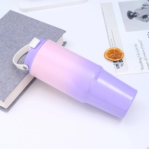 Detail of 30oz gradient pink-purple insulated tumbler with white handle on a white desk