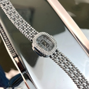 Close-up of elegant silver quartz watch with black dial and crystal mesh strap
