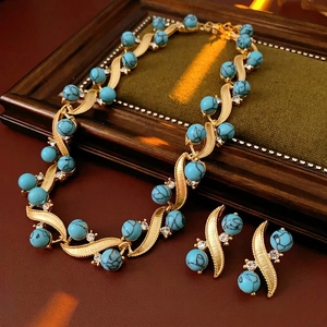 Vintage jewelry set with turquoise beads and rhinestones on wood and green velvet