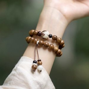 Close-up of double-loop brown wooden Buddhist prayer beads with tassels worn on wrist