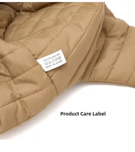 Nahaufnahme des Pflegeetiketts und 100% Polyester-Gewebe einer khakifarbenen Fliegermütze