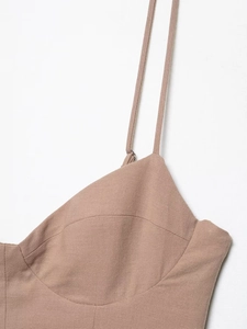 Detail of light brown midi dress featuring thin straps and precise stitching on the bodice