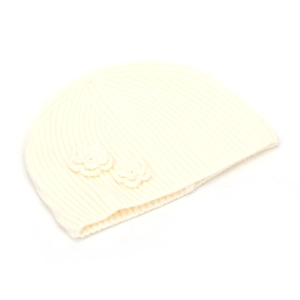 Close-up of cream white knit beanie with vertical ribbing and handmade flower details