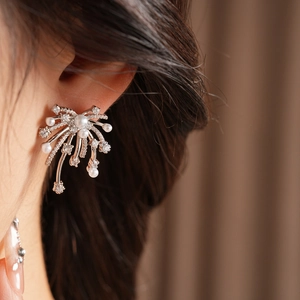 Close-up of silver-plated firework earrings with white pearls and sparkling cubic zirconia