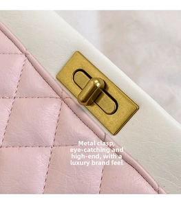 Detail of pink quilted leather crossbody bag with gold rotating metal lock and white trim