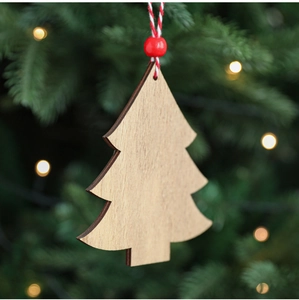 Detail of wooden Christmas tree pendant with red beads hanging on a glowing festive tree