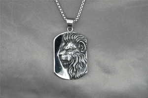 Macro shot of silver embossed lion head pendant on rectangular steel military tag