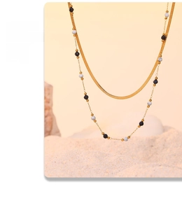 Close-up of gold layered snake chain necklace with elegant lapis lazuli beaded accents