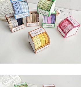 Detail of candy-colored elastic hair bands in branded boxes showing strong elasticity