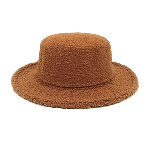 Detailed macro view of dark brown faux lamb wool texture on a flat-top winter hat