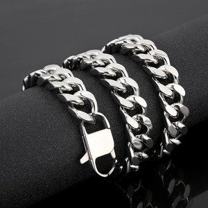 Polished silver Cuban link chain necklace with lobster clasp on a dark jewelry display stand
