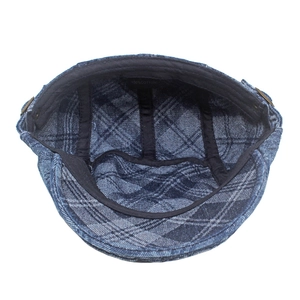 Detailed view of 100% cotton inner lining and label of a blue checkered newsboy cap