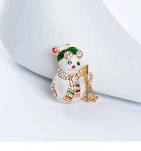 Detail of crystal snowman brooch with green ski goggles and golden snowboards