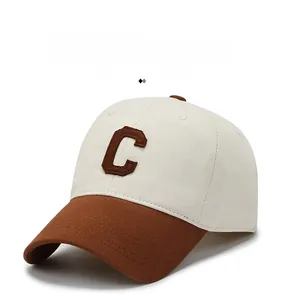 Close-up of beige canvas baseball cap with brown brim and 3D embroidered C letter