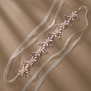 Elegant rose gold bridal flower headband with pearls and rhinestones on brown texture