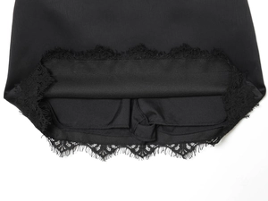 Detailansicht der schwarzen Satin-Shorts mit feiner Wimpernspitze und präzisen Nähten