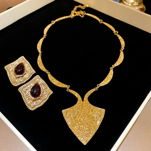 Close-up of vintage gold jewelry set with red gemstones in a black velvet gift box