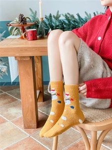 Detail of ginger Christmas coral fleece socks with snowman embroidery on a model