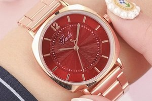Detail showing red sunray dial and rose gold metal strap on a lady quartz watch