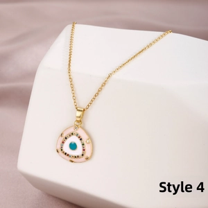Close-up of evil eye pendant with pink enamel and colorful crystals on stone base