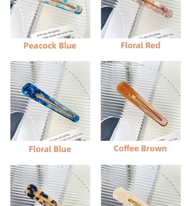 Close-up of assorted acetate teardrop clips in peacock blue, floral red and coffee colors