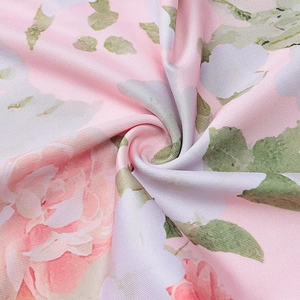 Detail of floral satin dress fabric with pink roses and soft draped textile texture