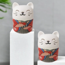 Detailed view of two lucky cat ceramic figurines in traditional red and blue kimonos