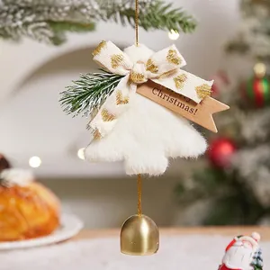 White faux fur Christmas tree ornament with a golden bell hanging on a festive branch