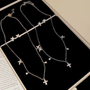 Detailed view of gold and silver cross jewelry sets with zircon studs and necklaces