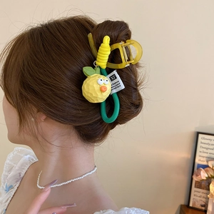 Detail of creative lemon hair claw and elastic band set worn on model's hair