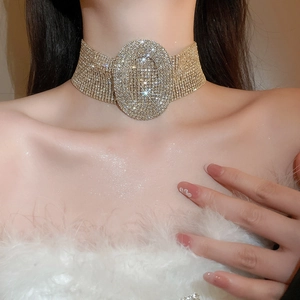 Close-up of a luxury gold choker necklace featuring a sparkling oval rhinestone centerpiece