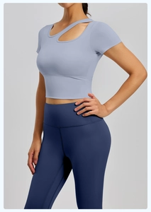 Dettaglio del crop top yoga blu con cut-out e leggings a vita alta su modella