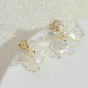 Detailed close-up of iridescent flower petal earrings with a golden heart-shaped clasp